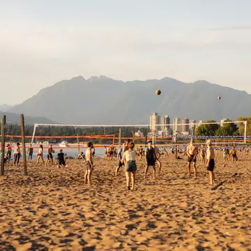 People playing volleyball on a sandy Kitsilano Beach in Vancouver.
