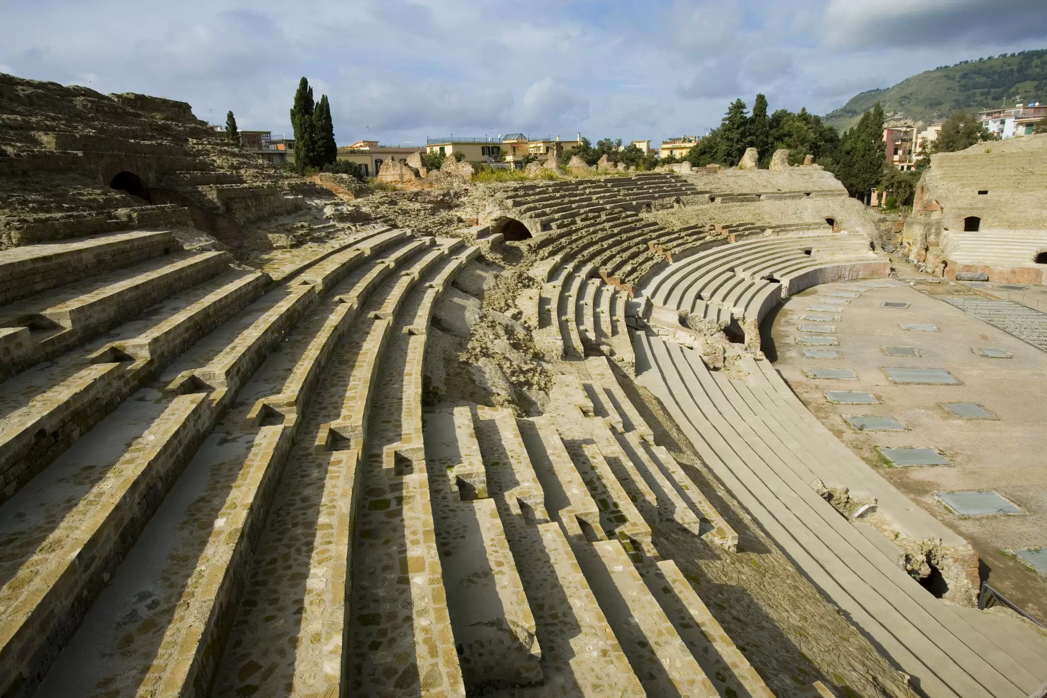 View of the Anfiteatro Flavio (Flavian Amphitheater) in Campi Flegrei with shadows cast on the stone steps of the amphitheater