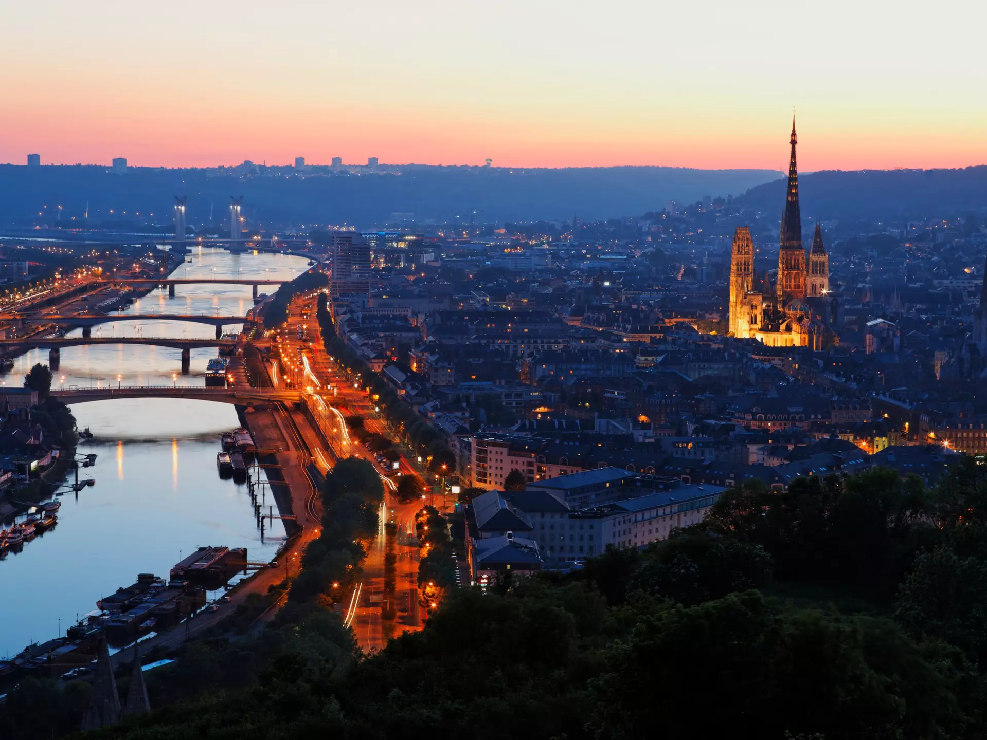 A riverside city at dusk. A large cathdral stands in the centre of the historic part of the city.
