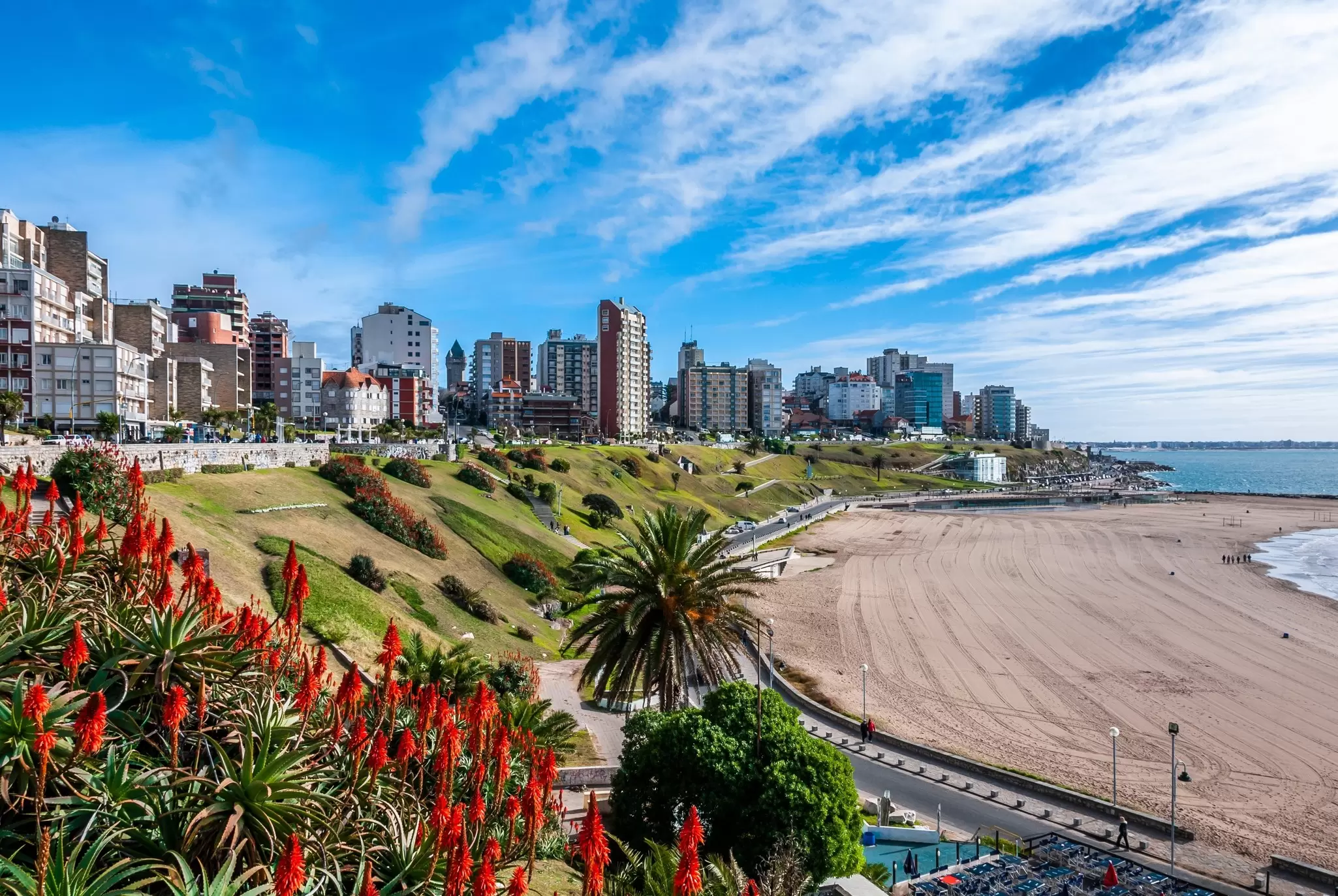 A sandy beach backed by high-rise apartment buildings.