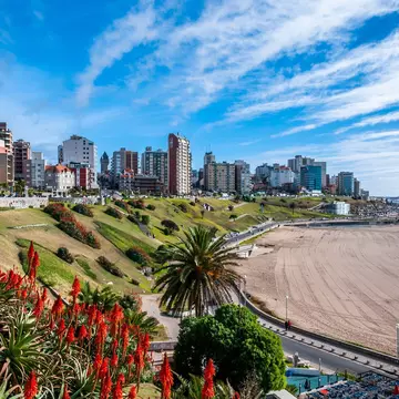 A sandy beach backed by high-rise apartment buildings.