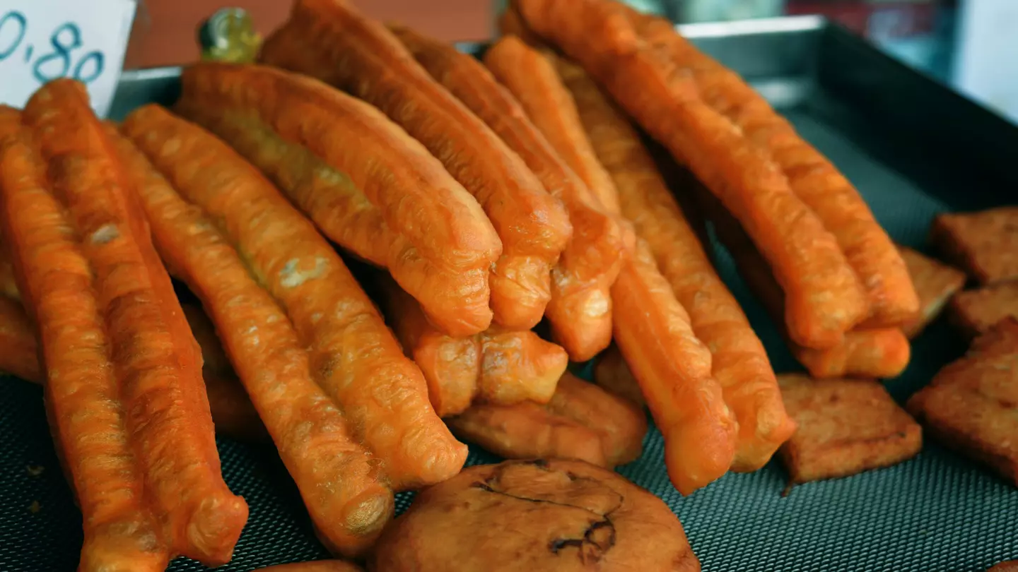 Two large cans of Saltbox Brewery's Crustacean Elation Ale sitting side-by-side on a bar table.