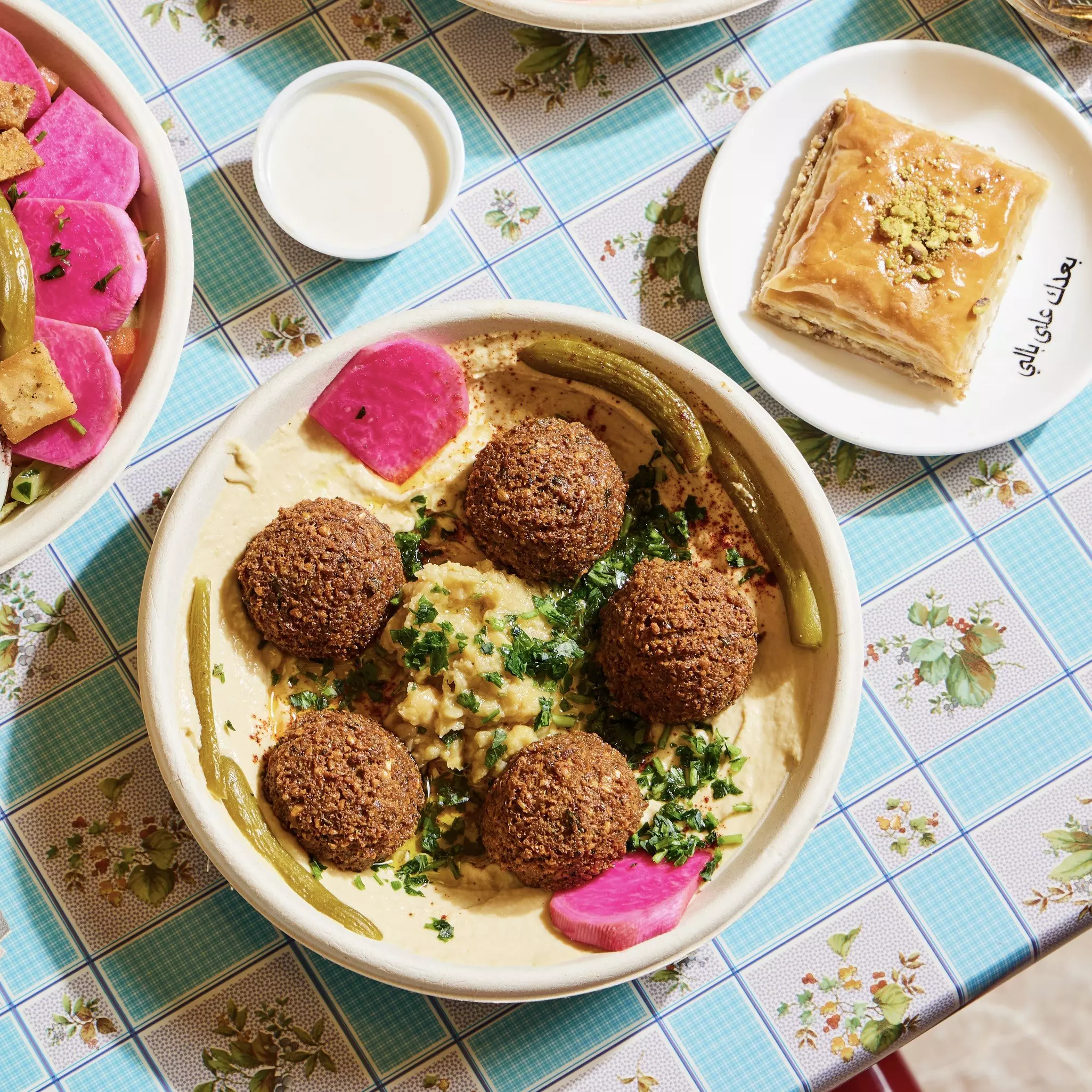 Falafel and other food at is photographed overhead on a patterned table.