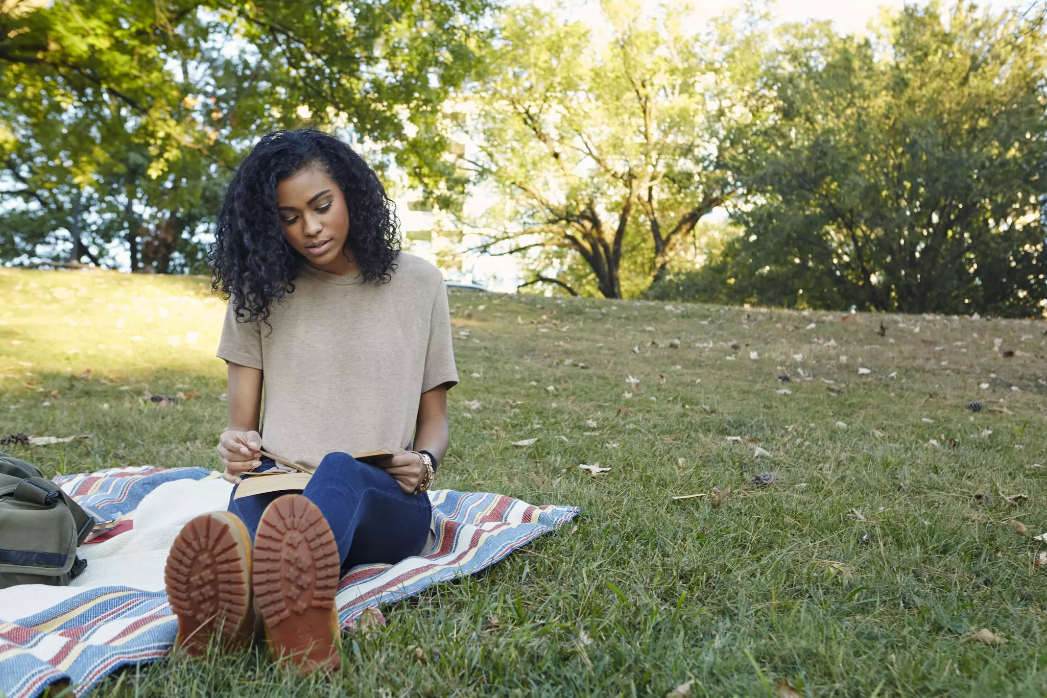 College Student reading in a city park