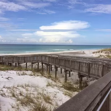 A boardwalk over sandy dunes by the sea in Florida.
