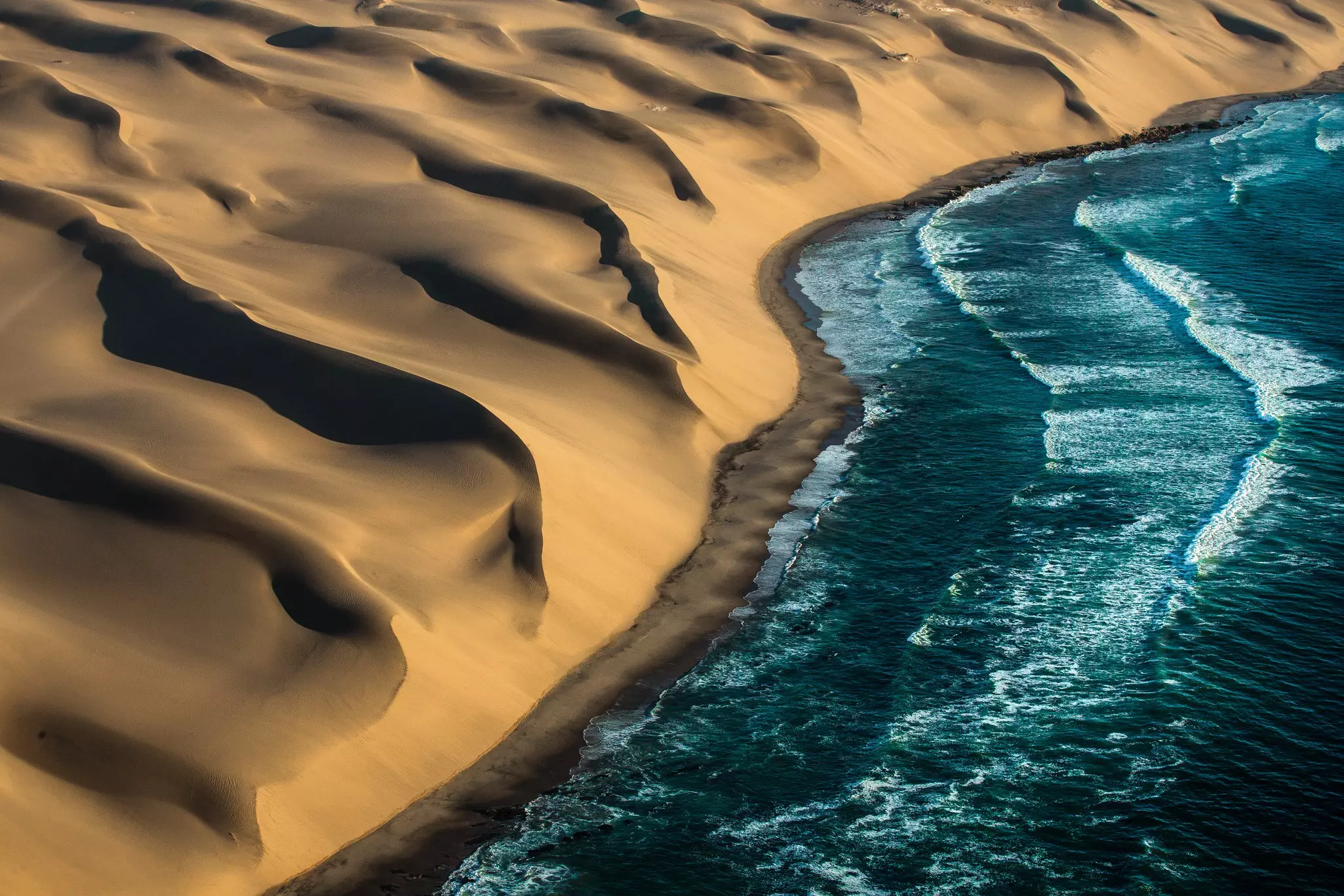 Views of dunes hitting the ocean on the Skeleton Coast, Namibia.