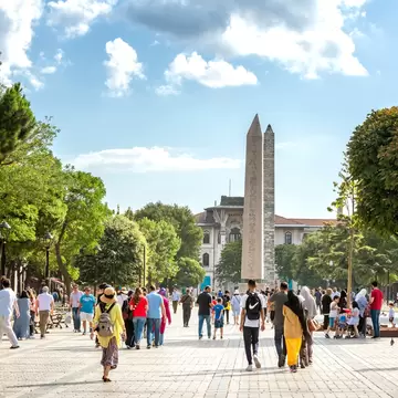 People walking at Sultan Ahmet Square (The Old Hippodrome Of Constantinople), famous tourist attraction and landmark of Istanbul's historic peninsula.