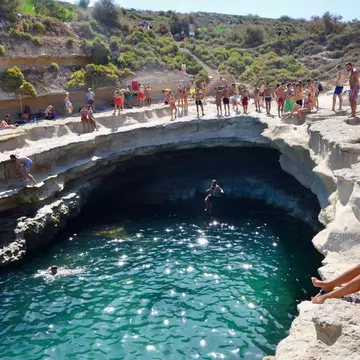 Swimmers and divers sitting around a curved-shape opening to water