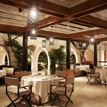 The interior of the Wolfgang Puck restaurant at the Hotel Bel-Air with a view out to the garden terrace
