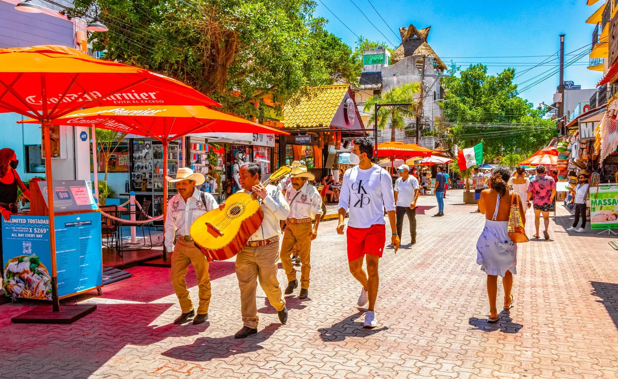 People walking along the colorful street of La Quinta Avenida in Playa del Carmen. 