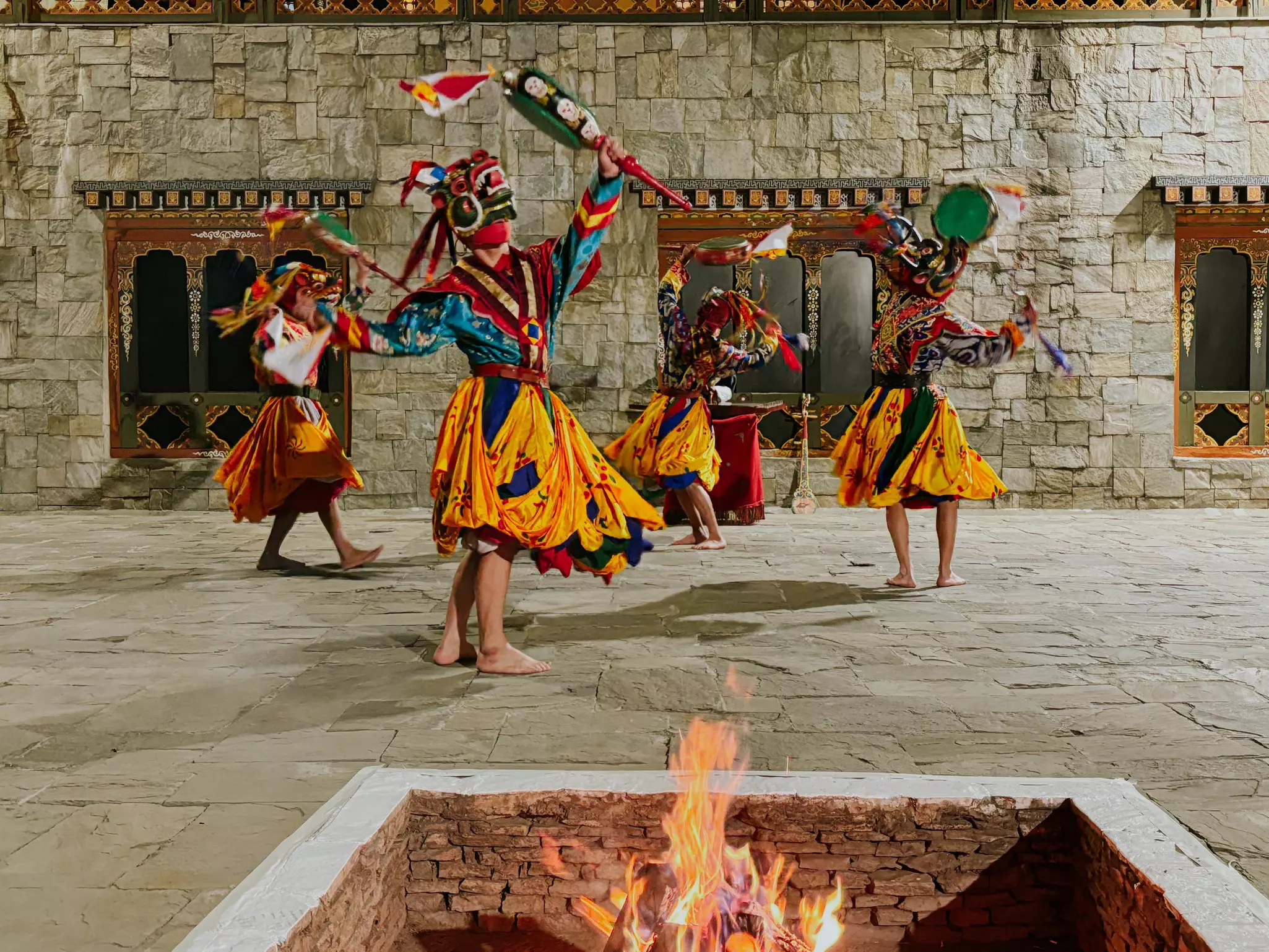 Dancers in traditional masks perform in a hotel courtyard in Bhutan.