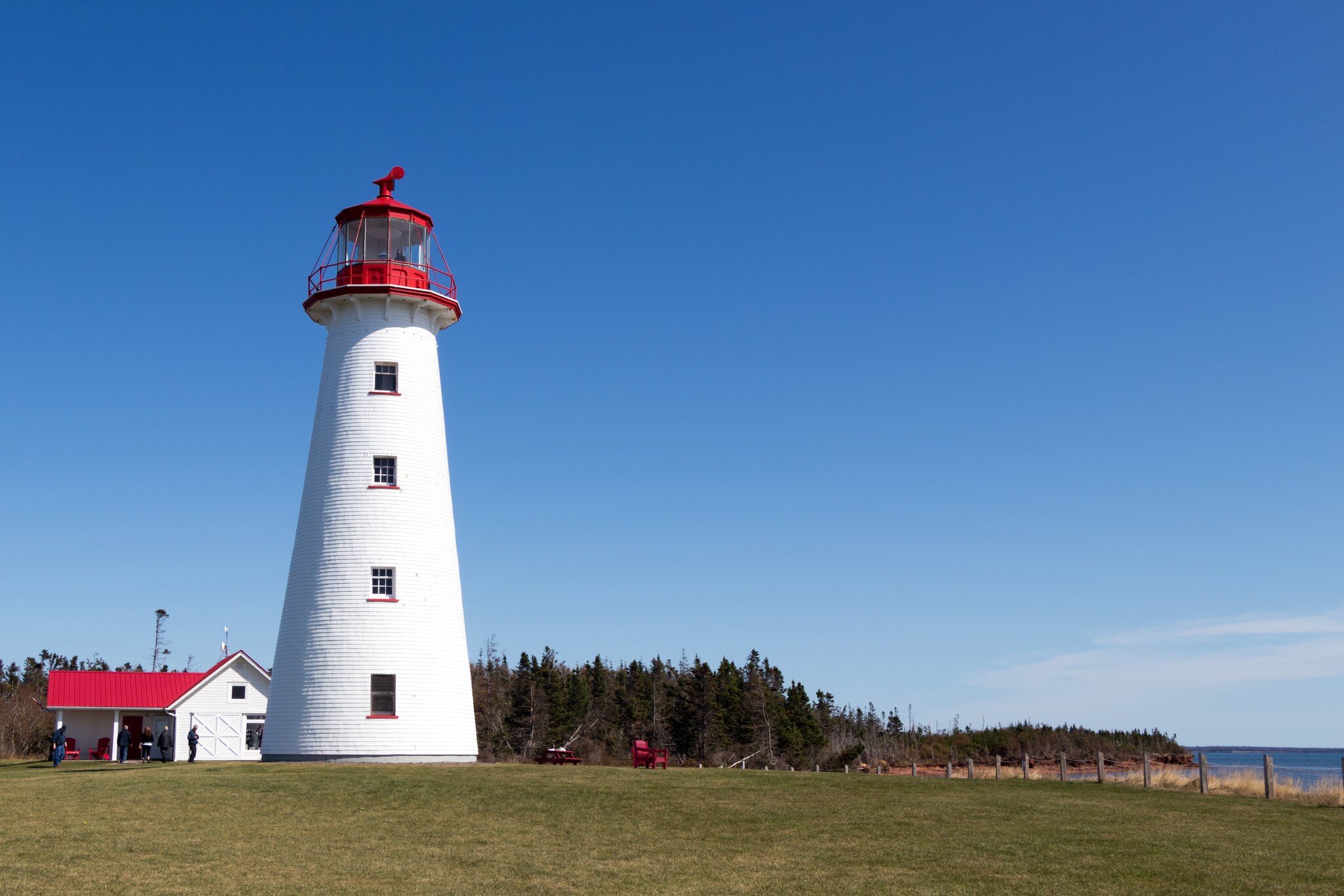 View of Point Prim Lighthouse against a blue sky in PEI, Canada.