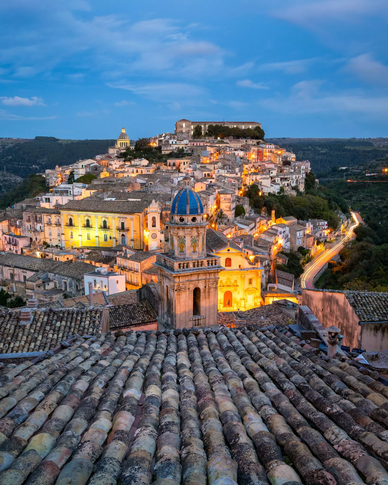 View of Ragusa (Ragusa Ibla) rooftops a UNESCO heritage town on Italian island of Sicily at dusk with street lights 