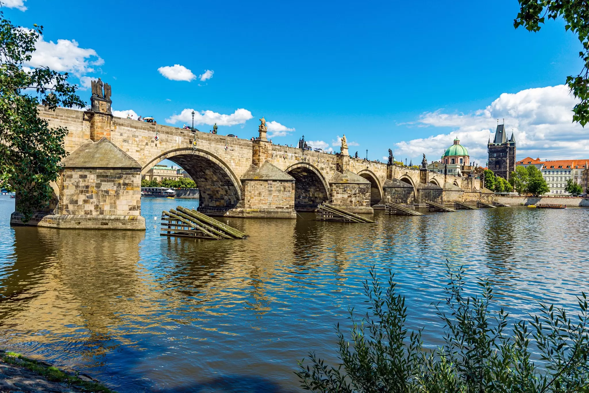View of the Charles Bridge Crossing the Vlata River on a sunny day in Prague, Czechia.