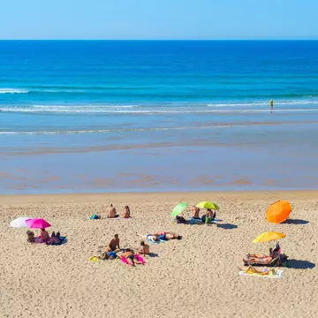 People at the beach on a summer sunny day in Odeceixe, Portugal.