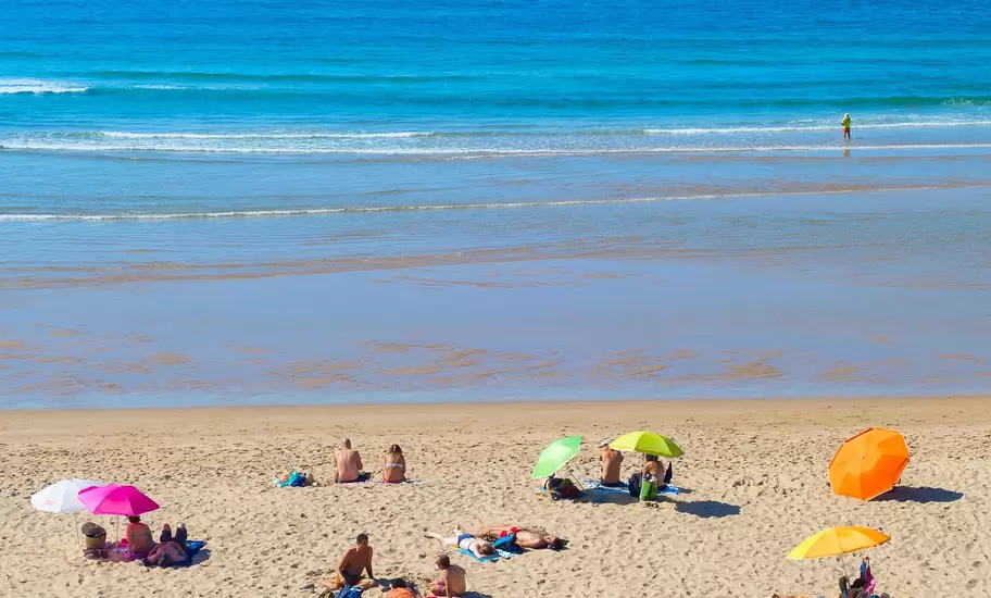 People at the beach on a summer sunny day in Odeceixe, Portugal.