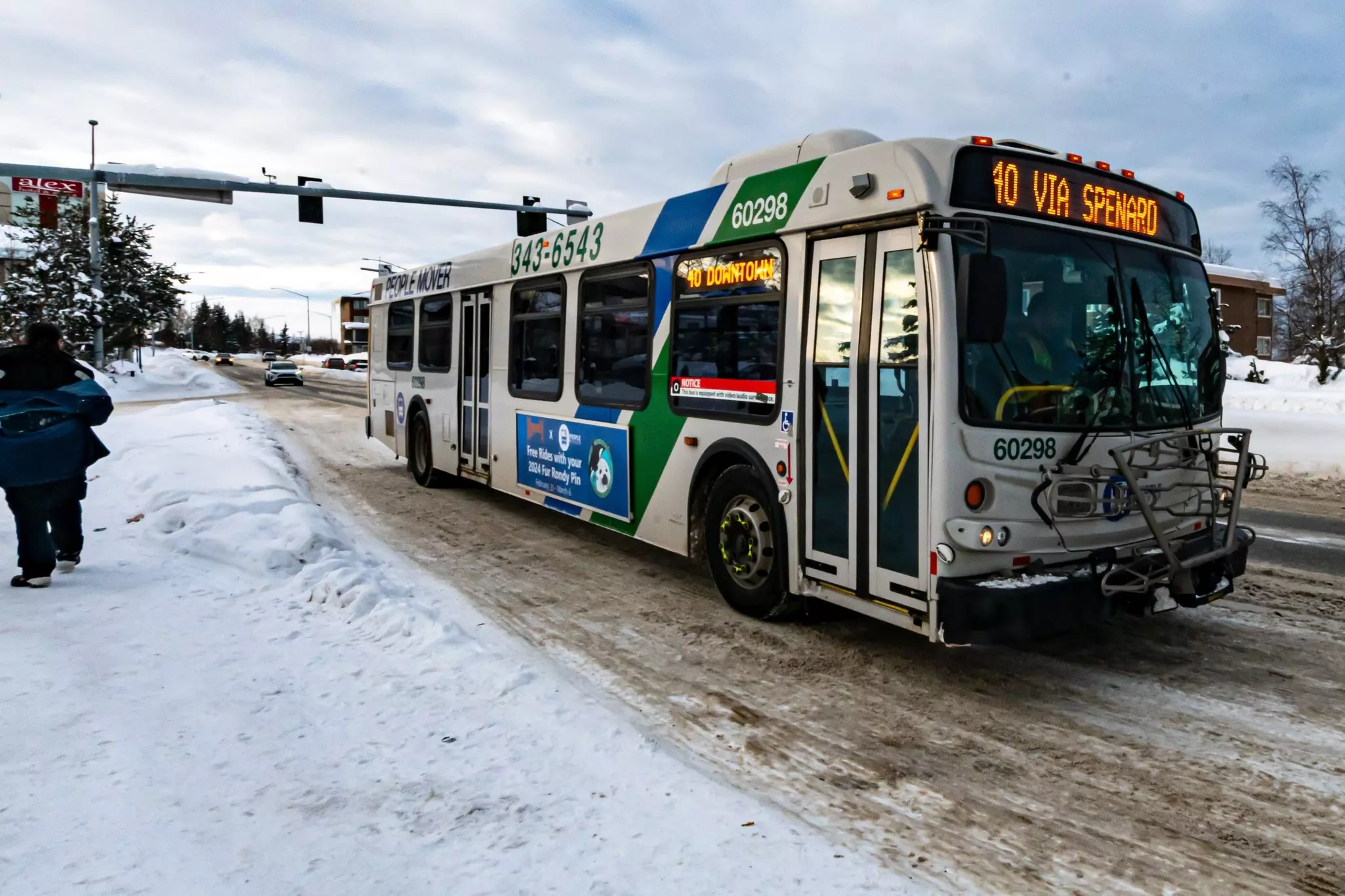 A bus navigates a snowy city street.