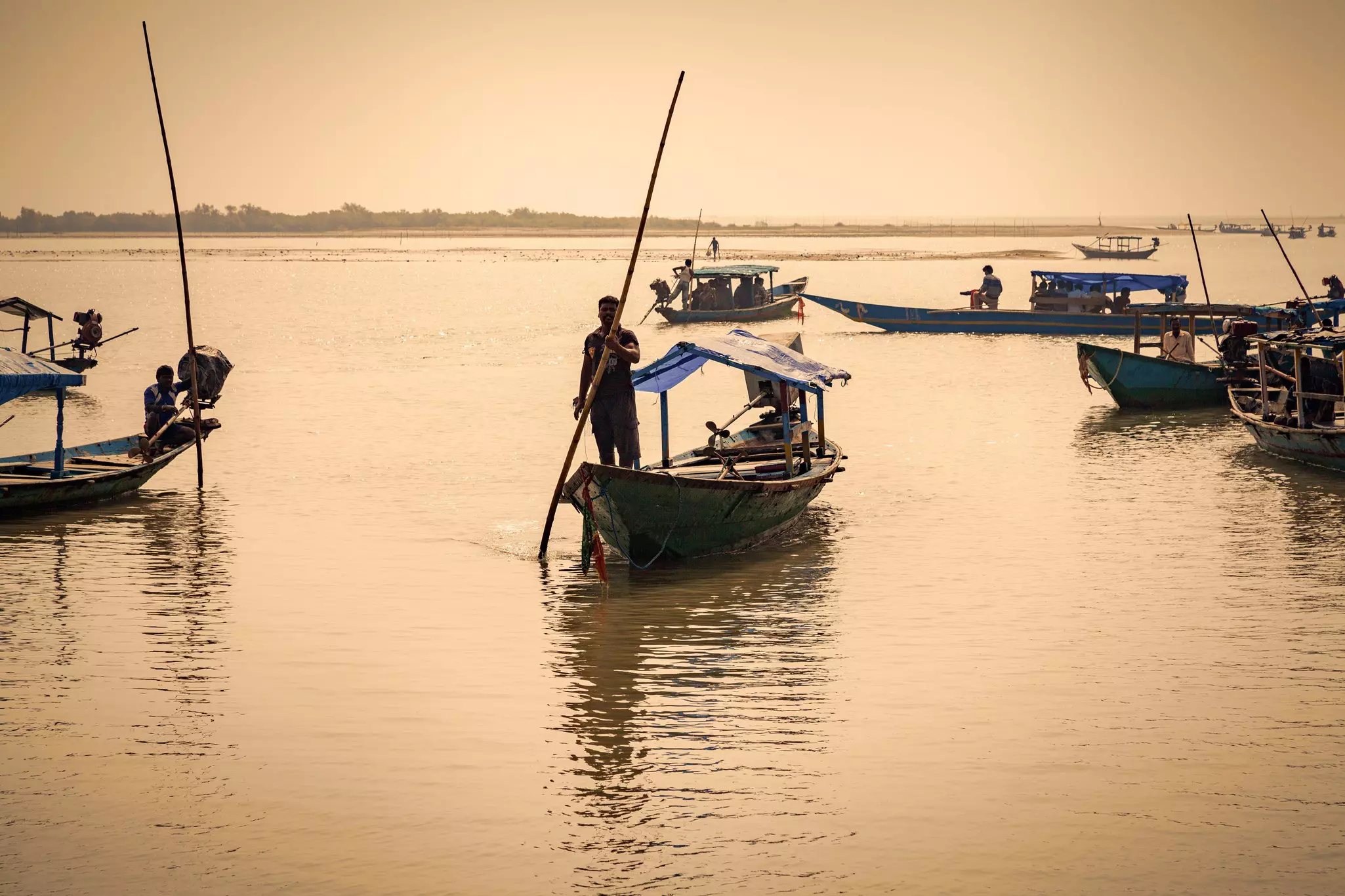 Boats on the water during sunrise on Lake Chilika. ©ImagesofIndia/Shutterstock