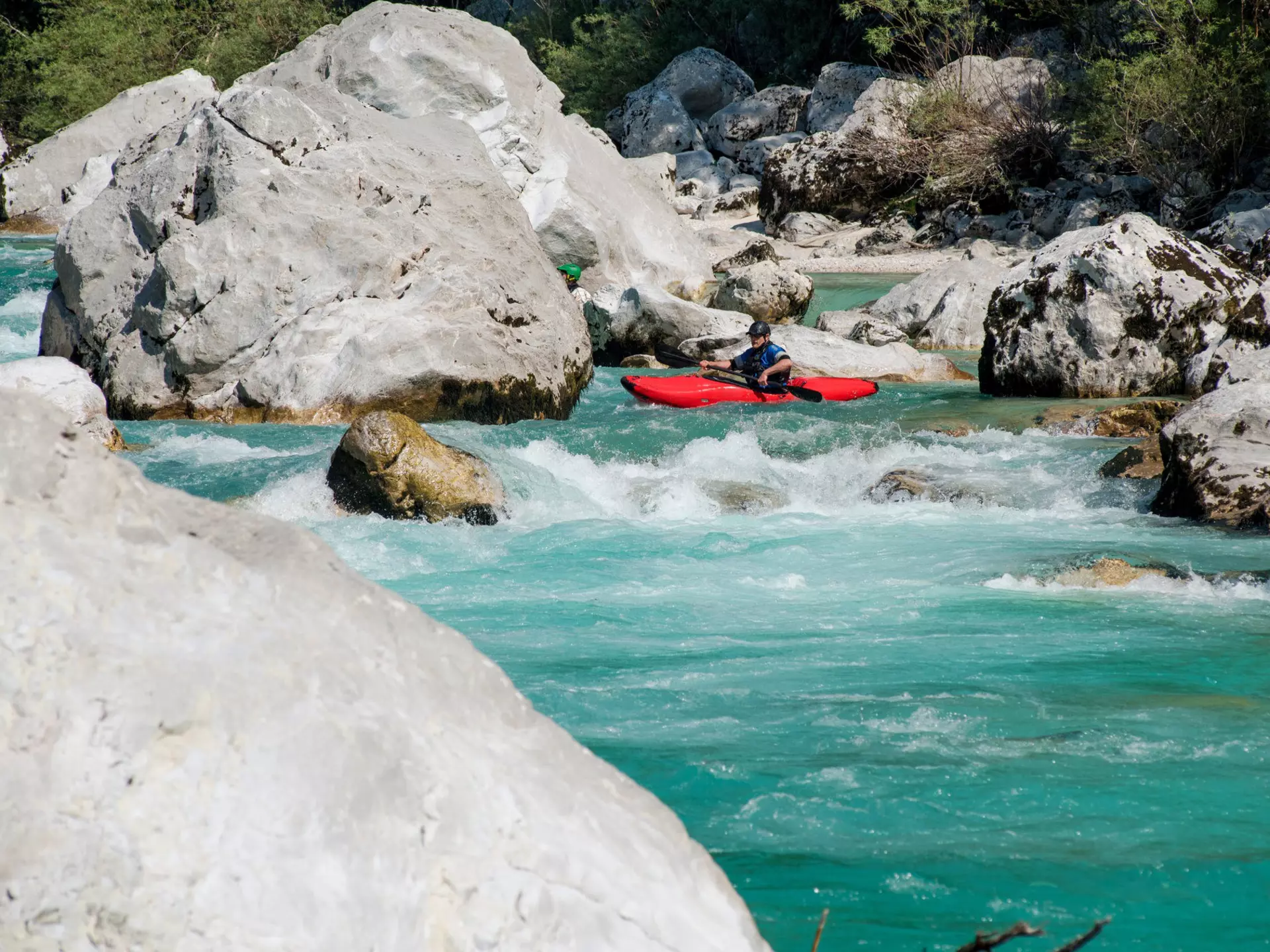 A man kayaking in the turquoise water of the river Soca, in Slovenia. CasarsaGuru / Getty Images