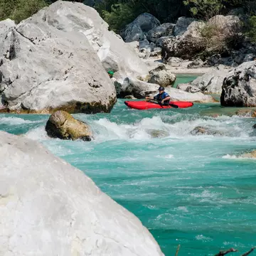 A man kayaking in the turquoise water of the river Soca, in Slovenia. CasarsaGuru / Getty Images