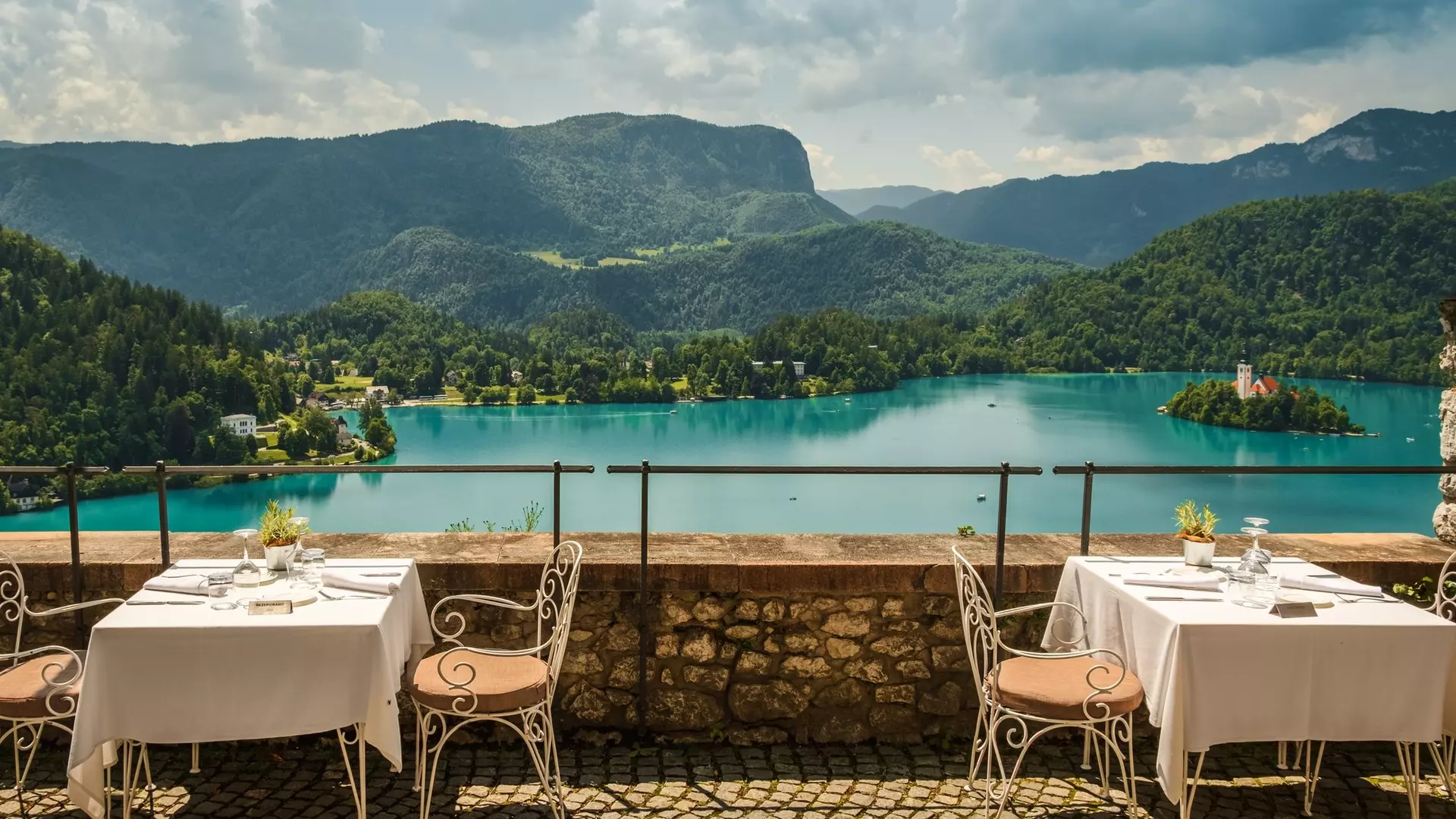 View of outdoor terrace of restaurant overlooking Lake Bled, Slovenia; Alps mountains in background