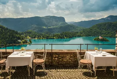 View of outdoor terrace of restaurant overlooking Lake Bled, Slovenia; Alps mountains in background