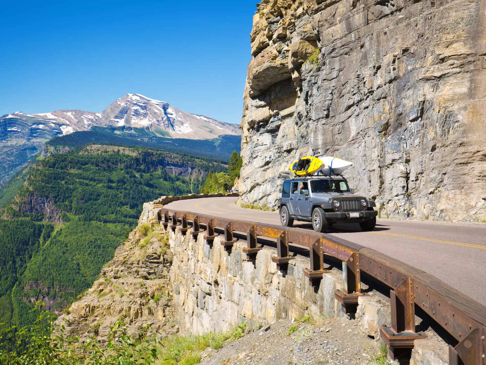 A driver rounds a corner on the Going To The Sun Road at Glacier National Park, Montana. USA.