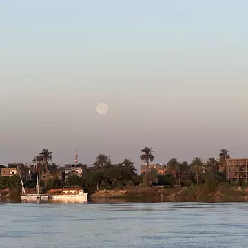 The moon at sunrise on the Nile River in Luxor as seen from aboard a riverboat