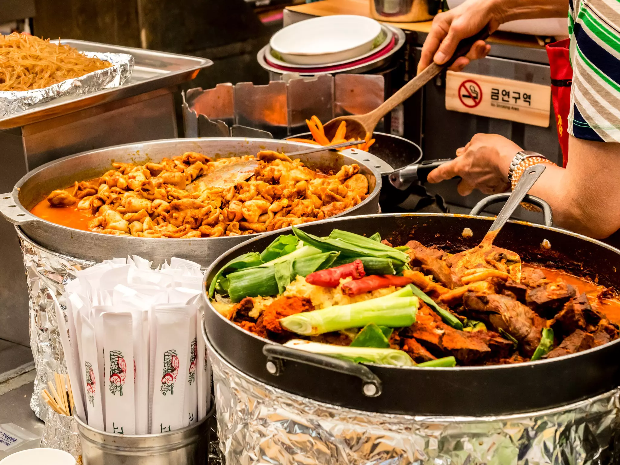 Large dishes of Korean food being prepared in a fresh-food market/