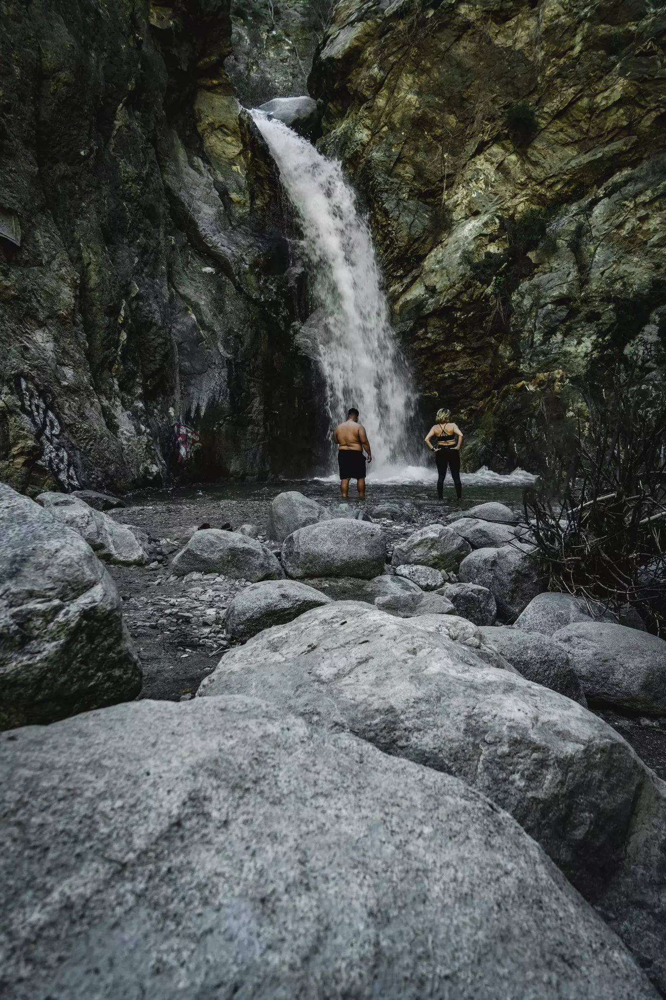 Two people admiring Eaton Canyon Falls on a hike