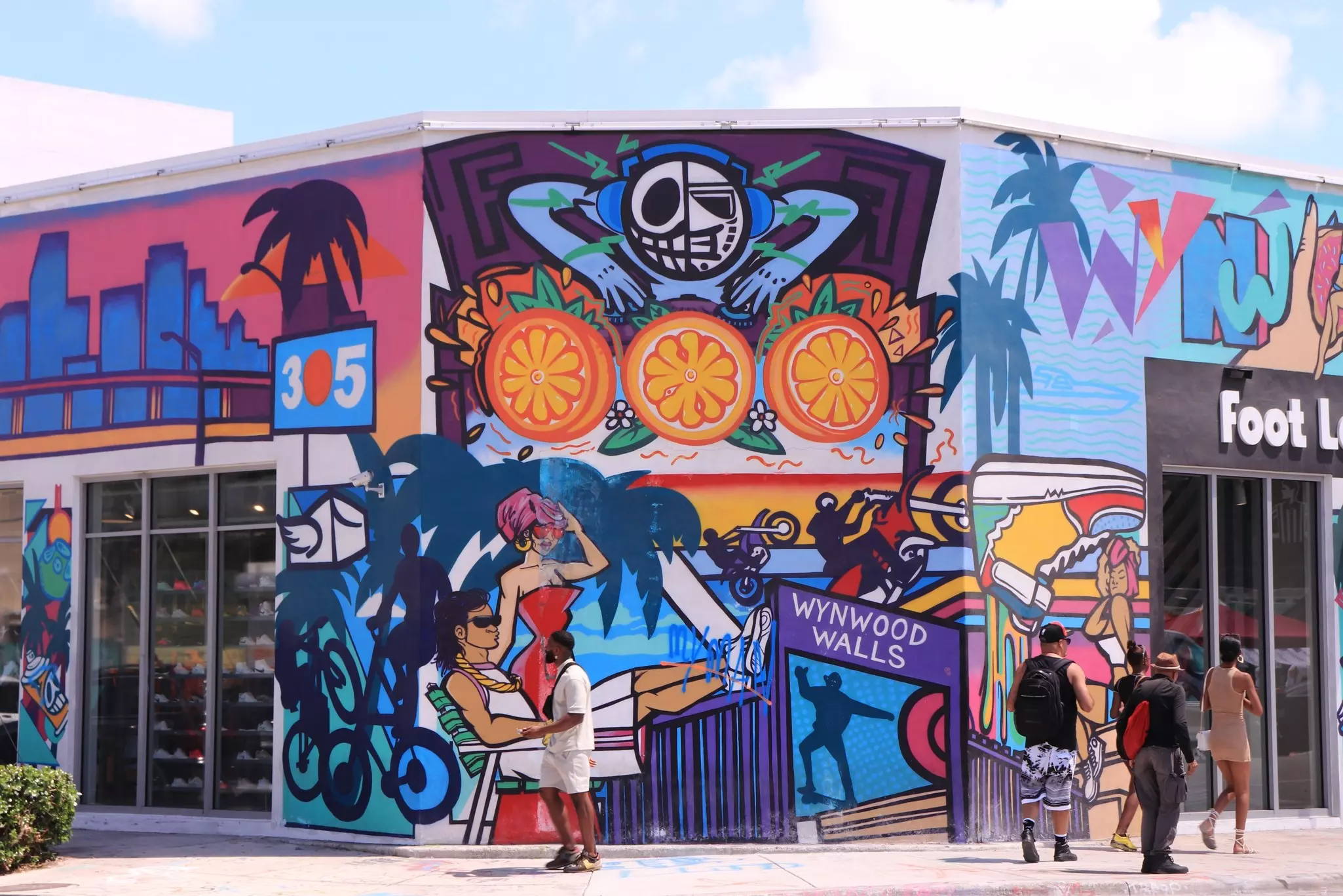 Colorful painted walls of Wynwood Walls in the Wynwood Arts District with people walking nearby.