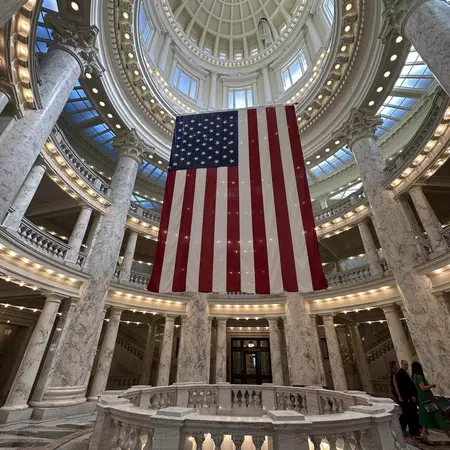 Rotunda with lights and a large US flag hanging from the ceiling