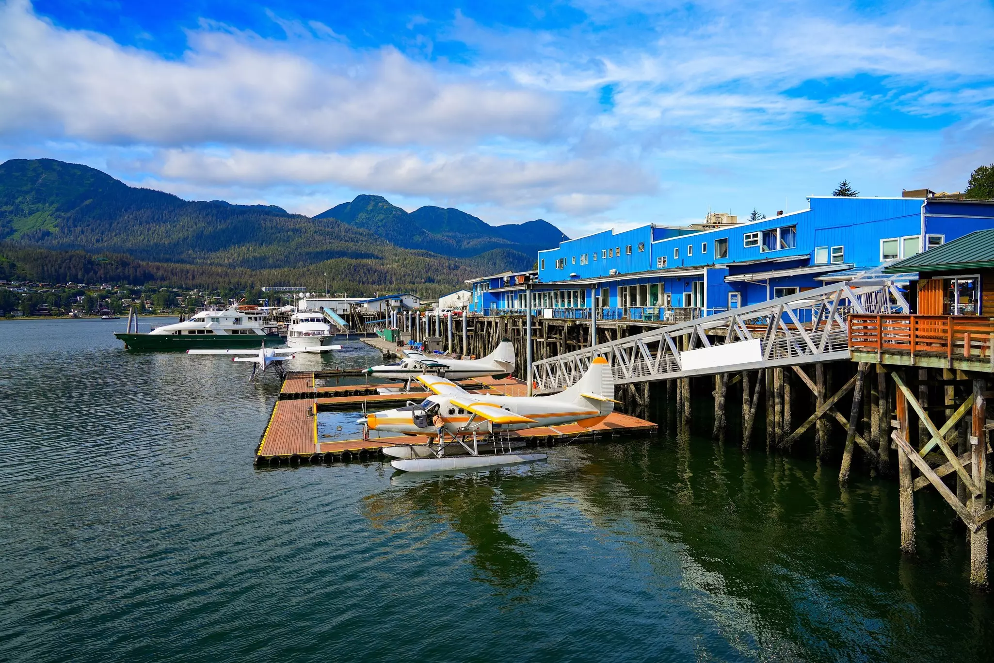 A small harbor airport with floatplanes docked by floating pontoons.