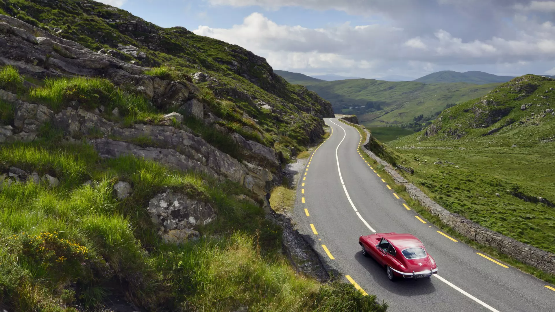 E-Type Jaguar driving on country road between Kenmare and Killarney.