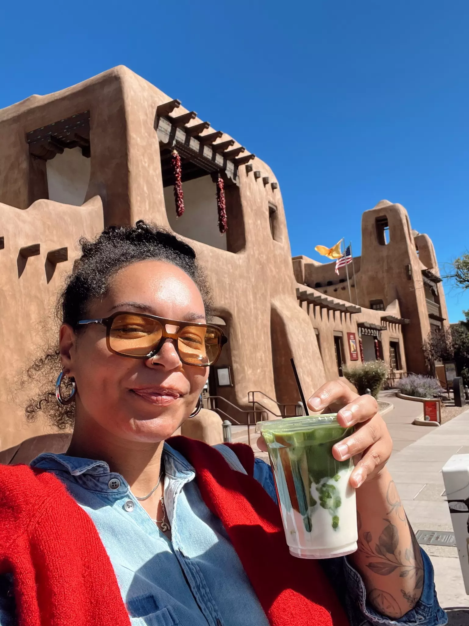 A woman holds a to-go cup of matcha.
