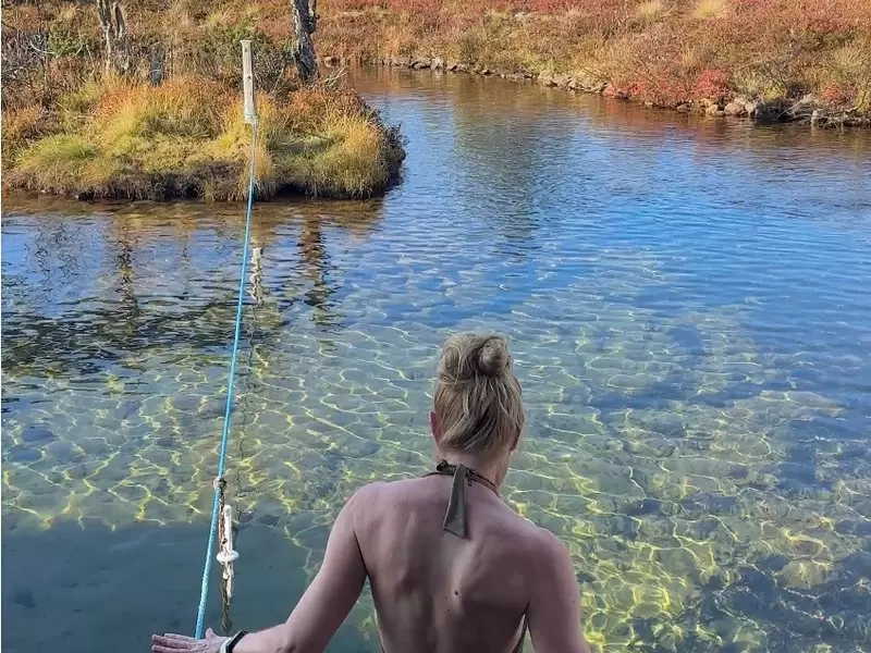 A woman taking a cold-water swim after a sauna in Lapland, Finland.