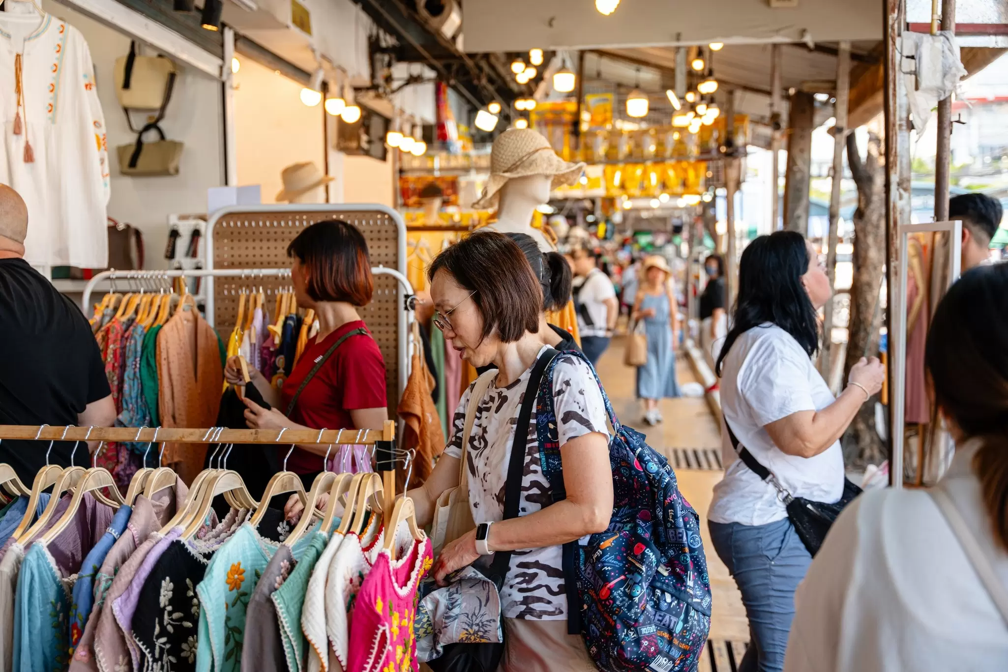 Crowds of people shopping at Chatuchak Weekend Market in Bangkok, Thailand.