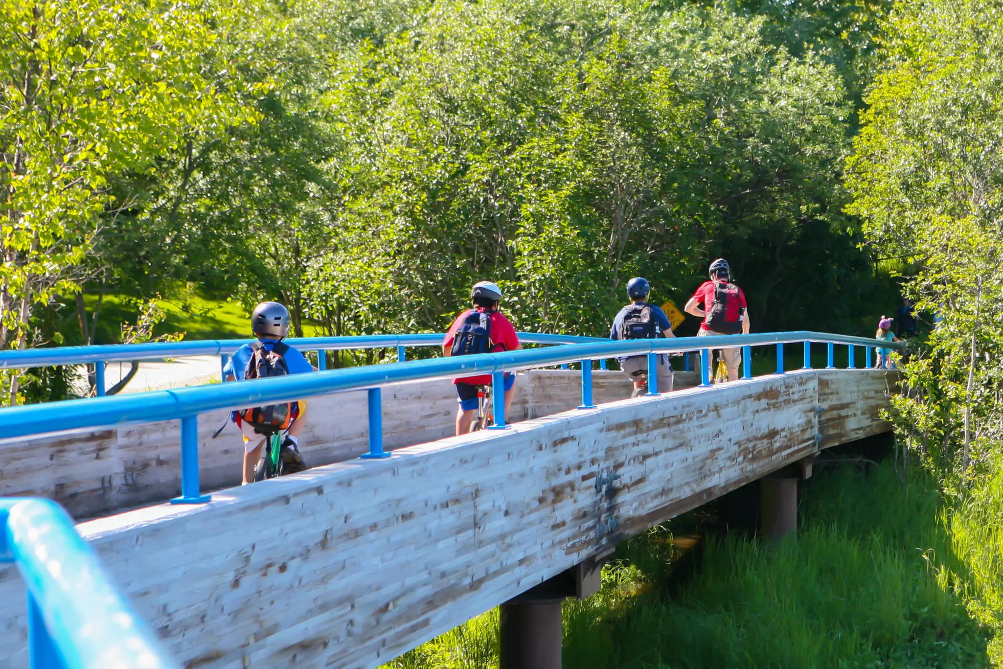 A family cycling across a bridge