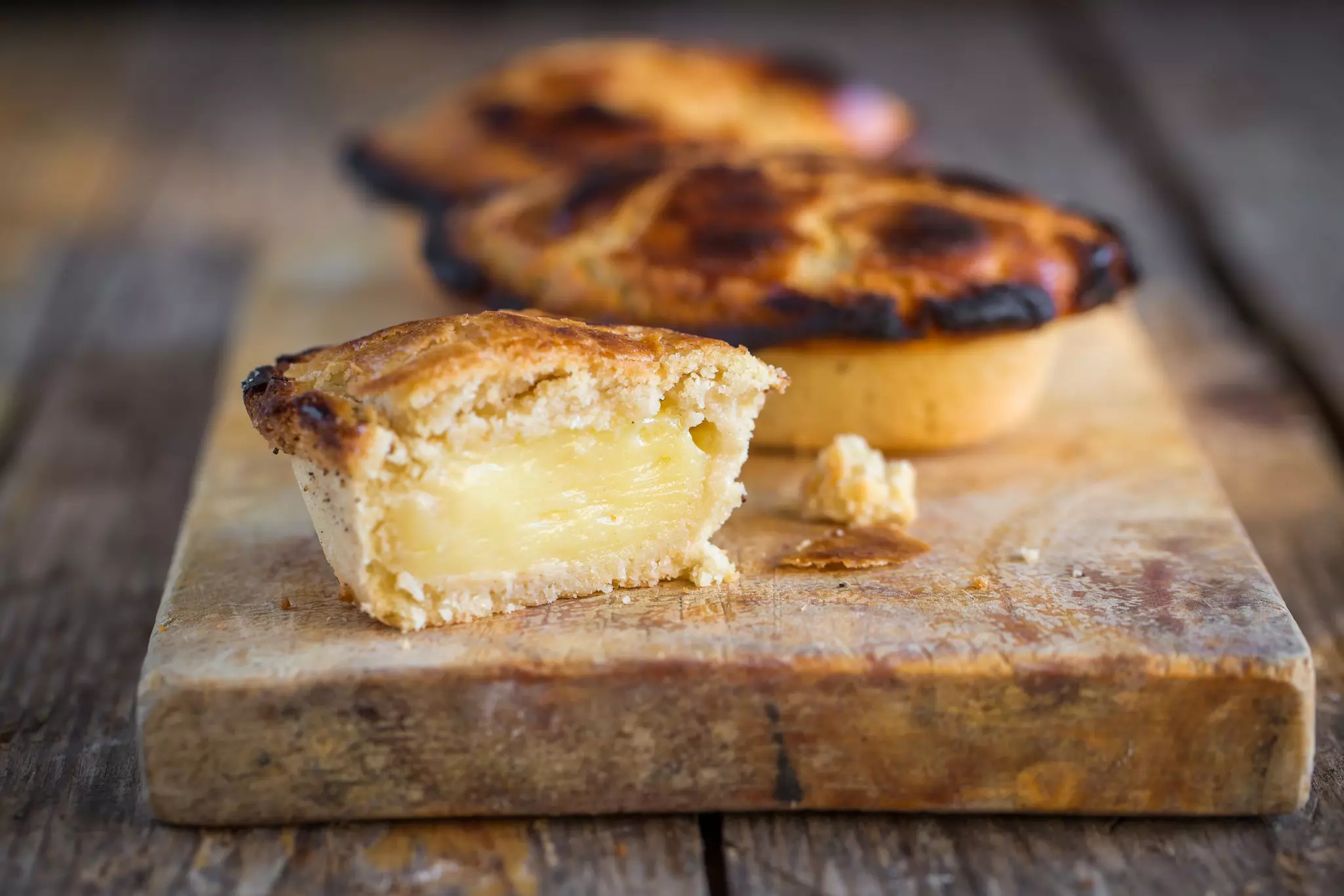 Traditional custard-filled pastries on a wooden board.
