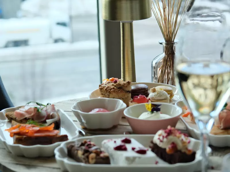 A table filled with small dishes of food for afternoon tea.