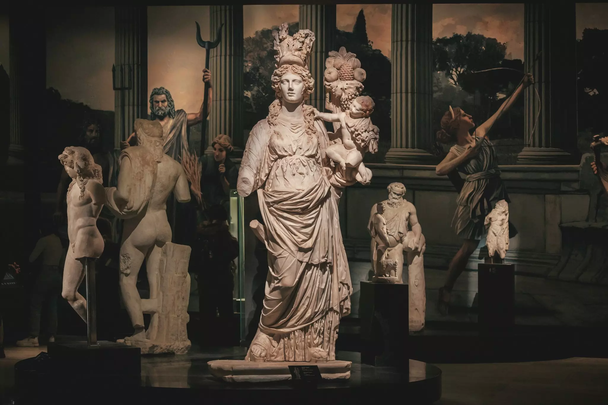 Marble statues on display in a darkened museum.