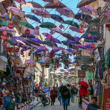 Colorful tourist market, Mercado de Las Brujas in La Paz, Bolivia, with umbrellas hanging from the top.