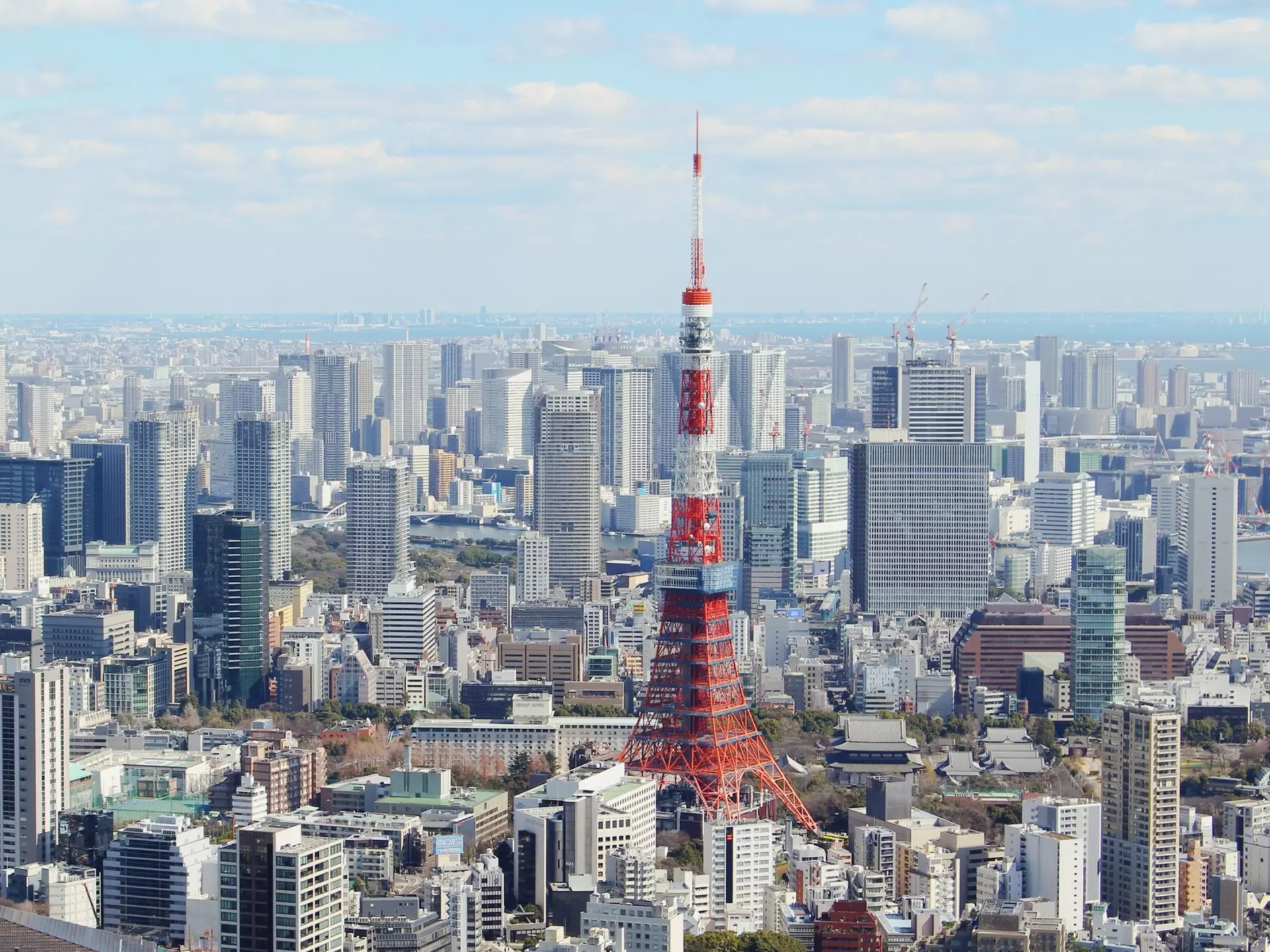 A skyscraper-filled downtown with a red tower rising from the cluster of buildings