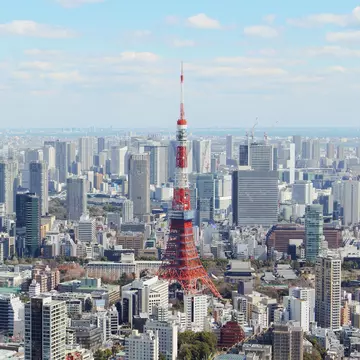 A skyscraper-filled downtown with a red tower rising from the cluster of buildings