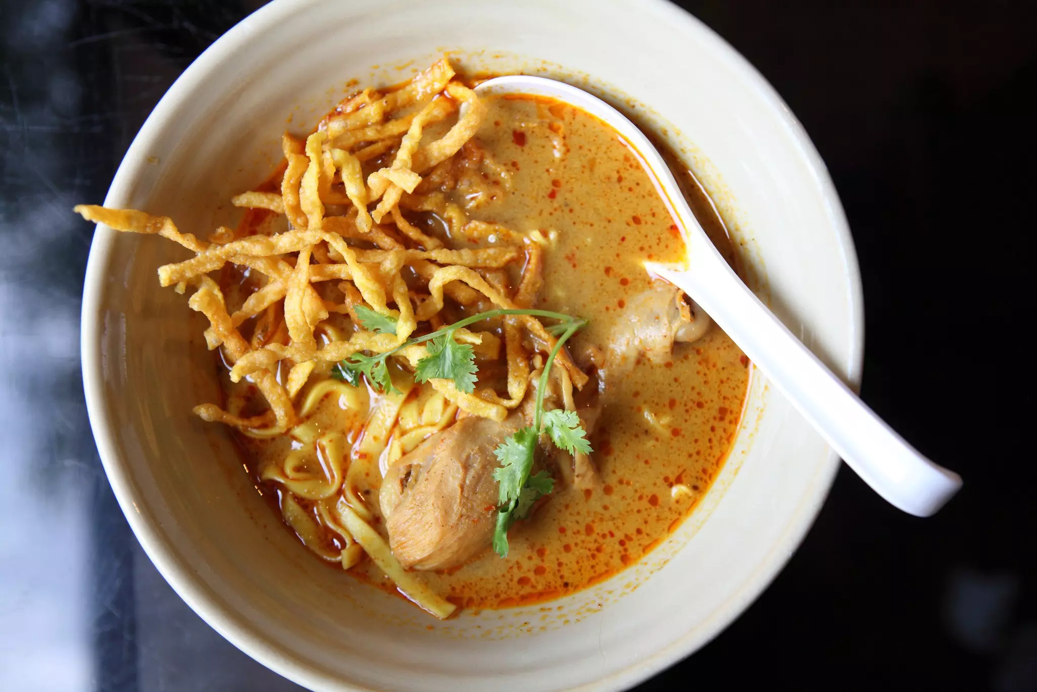 A bowl of hawker-style khao soi soup in Thailand.