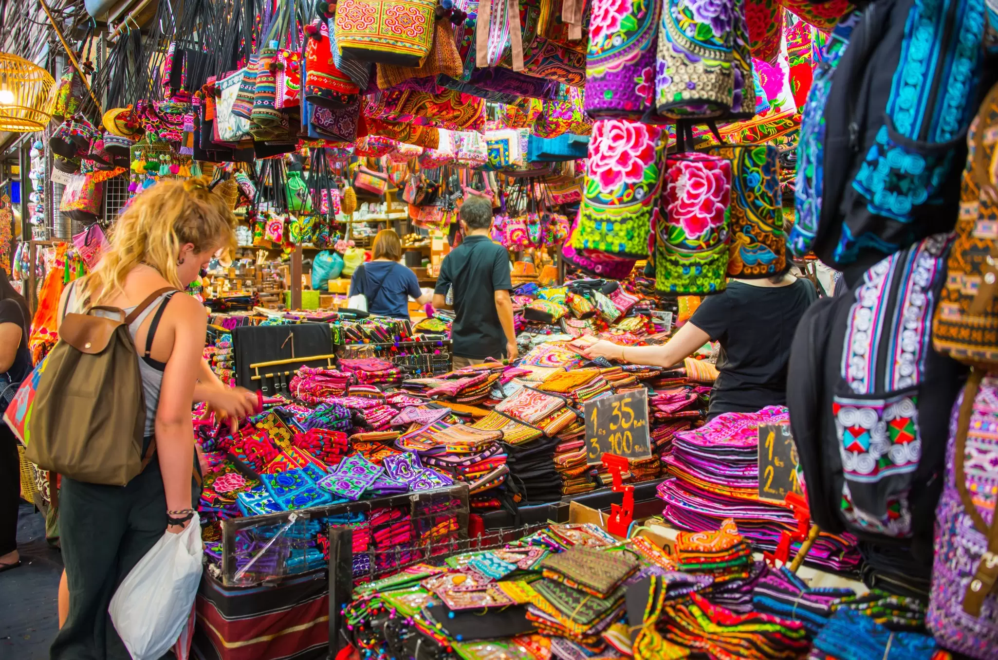 Tourists shopping for Thai handicraft souvenirs at Chatuchak Market in Bangkok, Thailand.