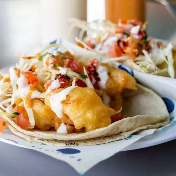 Baja California style fish and shrimp tacos, topped with cabbage, tomatoes, cilantro and a variety of salsas