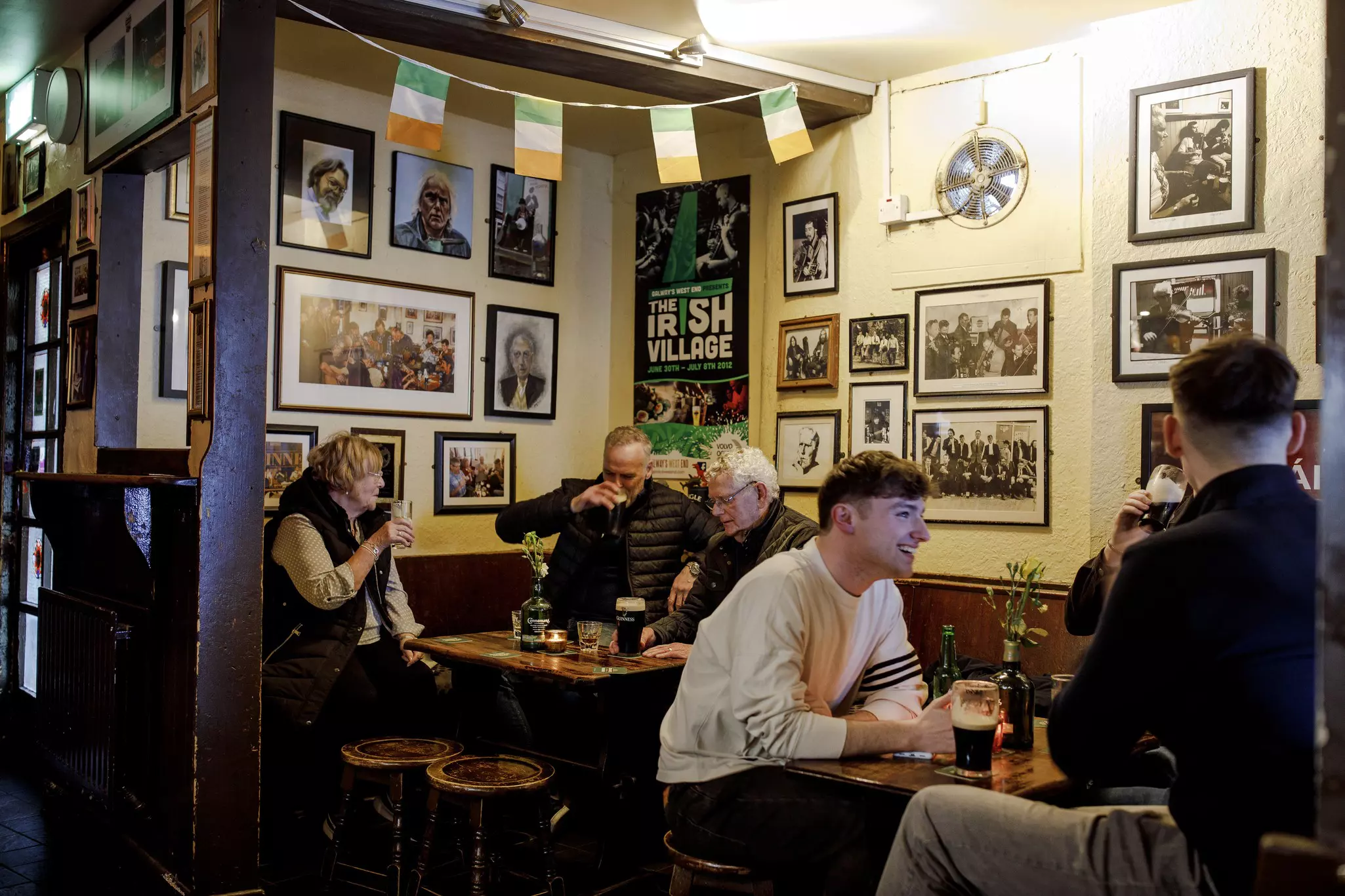 People drinking Guinesses at inside a pub