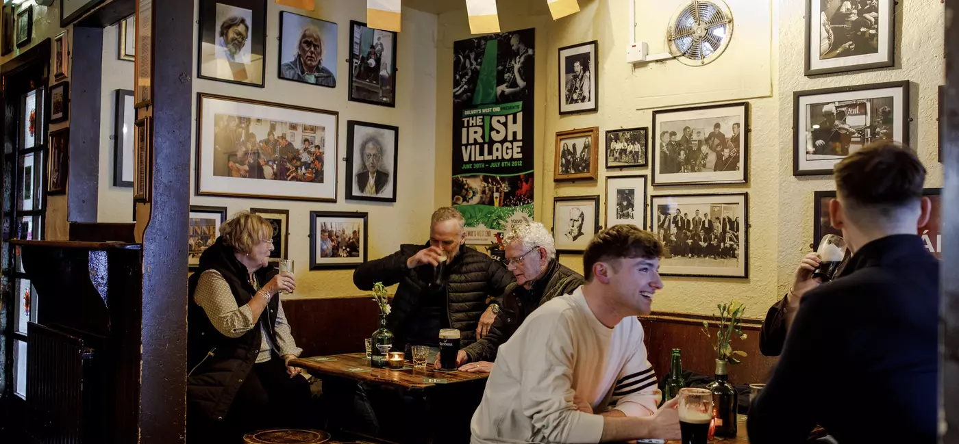 People drinking Guinesses at inside a pub