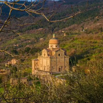 View of Santa Maria Nuova (Church of St Mary the New) among trees, just before sunset from Cortona, in Tuscany.